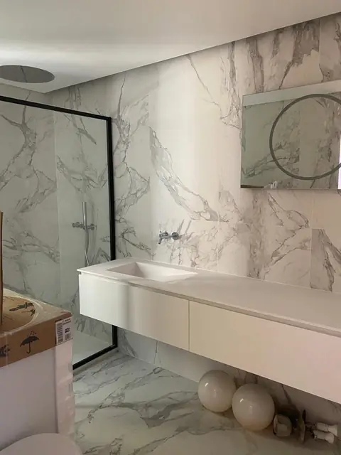 Casa de banho em cerâmico efeito mármore, com lavatório suspenso e duche