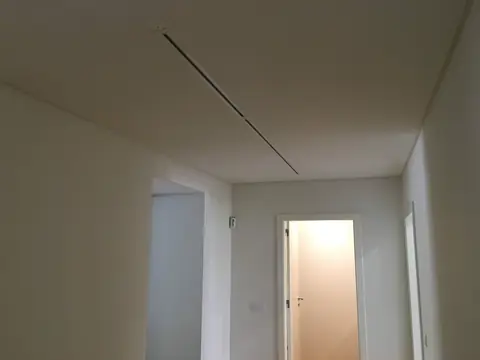 Teto liso com grelha linear de ventilação